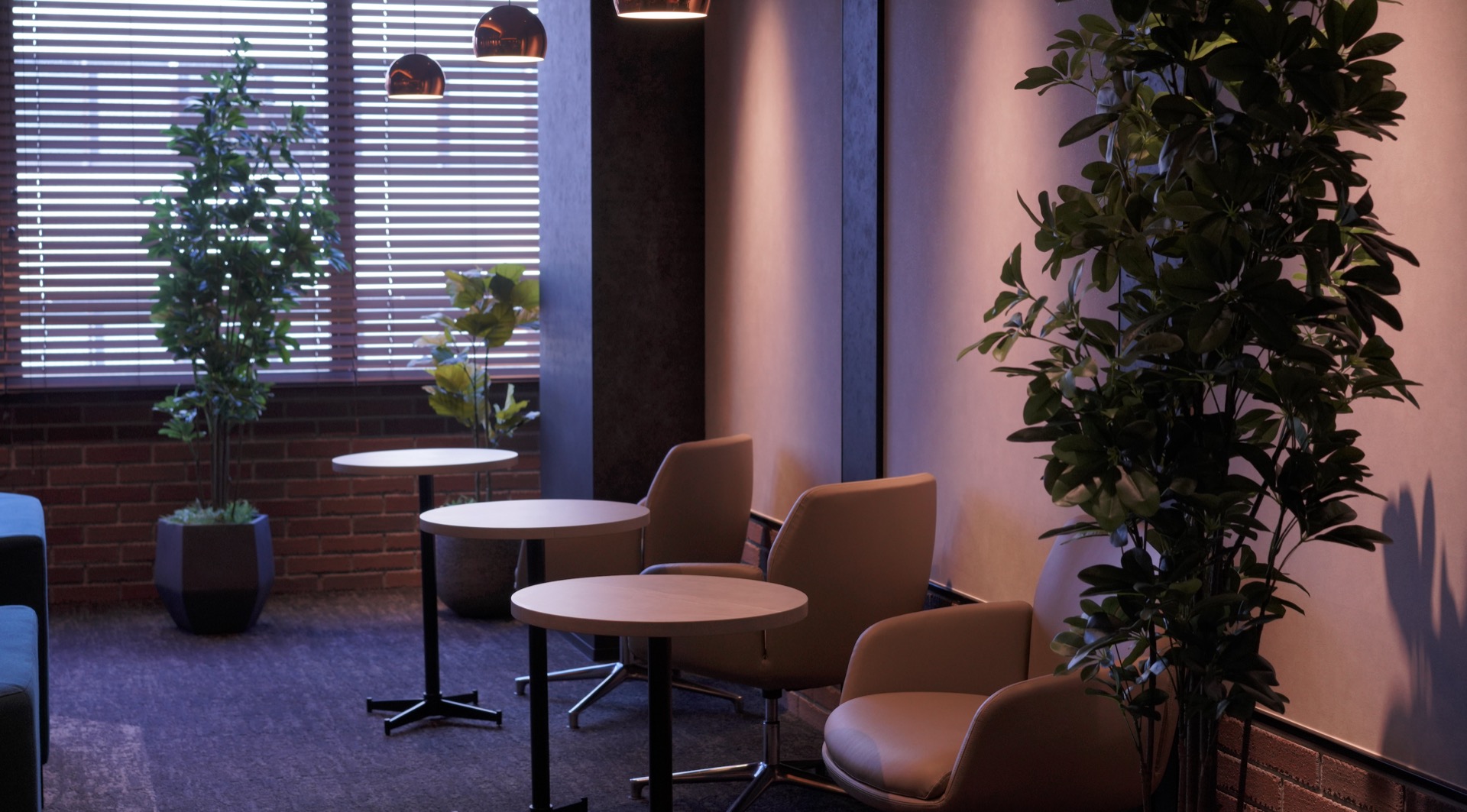 窓際に一人掛けの椅子席と丸テーブルが並ぶPONO 7階ラウンジ