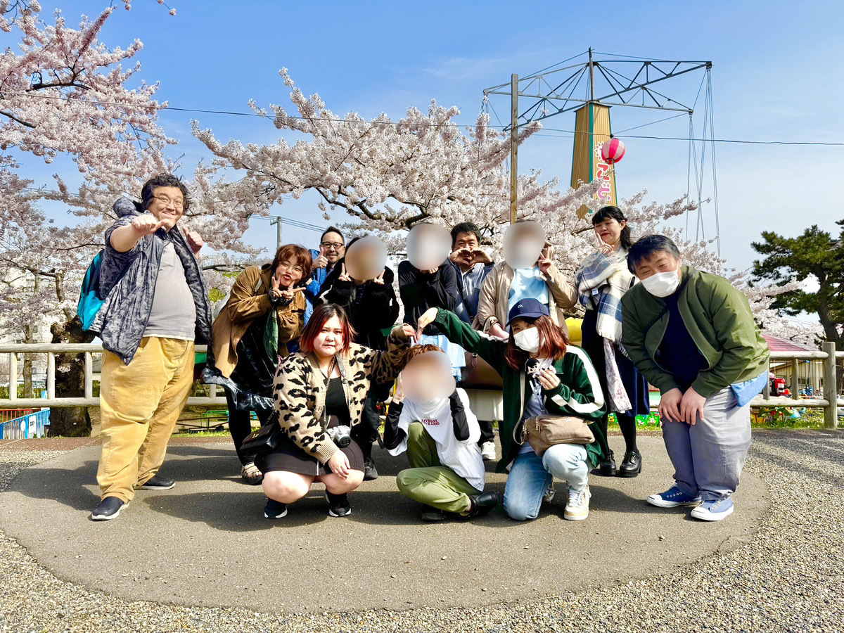 満開の桜の下、笑顔で集合するPONOの利用者さんとスタッフ