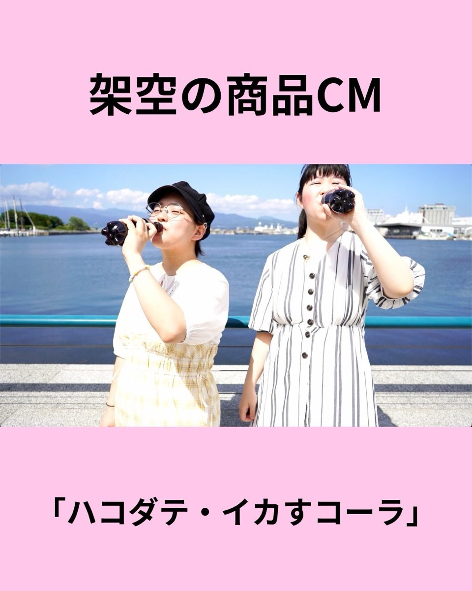 「架空の商品CM ハコダテ・イカすコーラ」と題されたCMの一場面。函館の海を背景に2人がコーラを飲んでいる