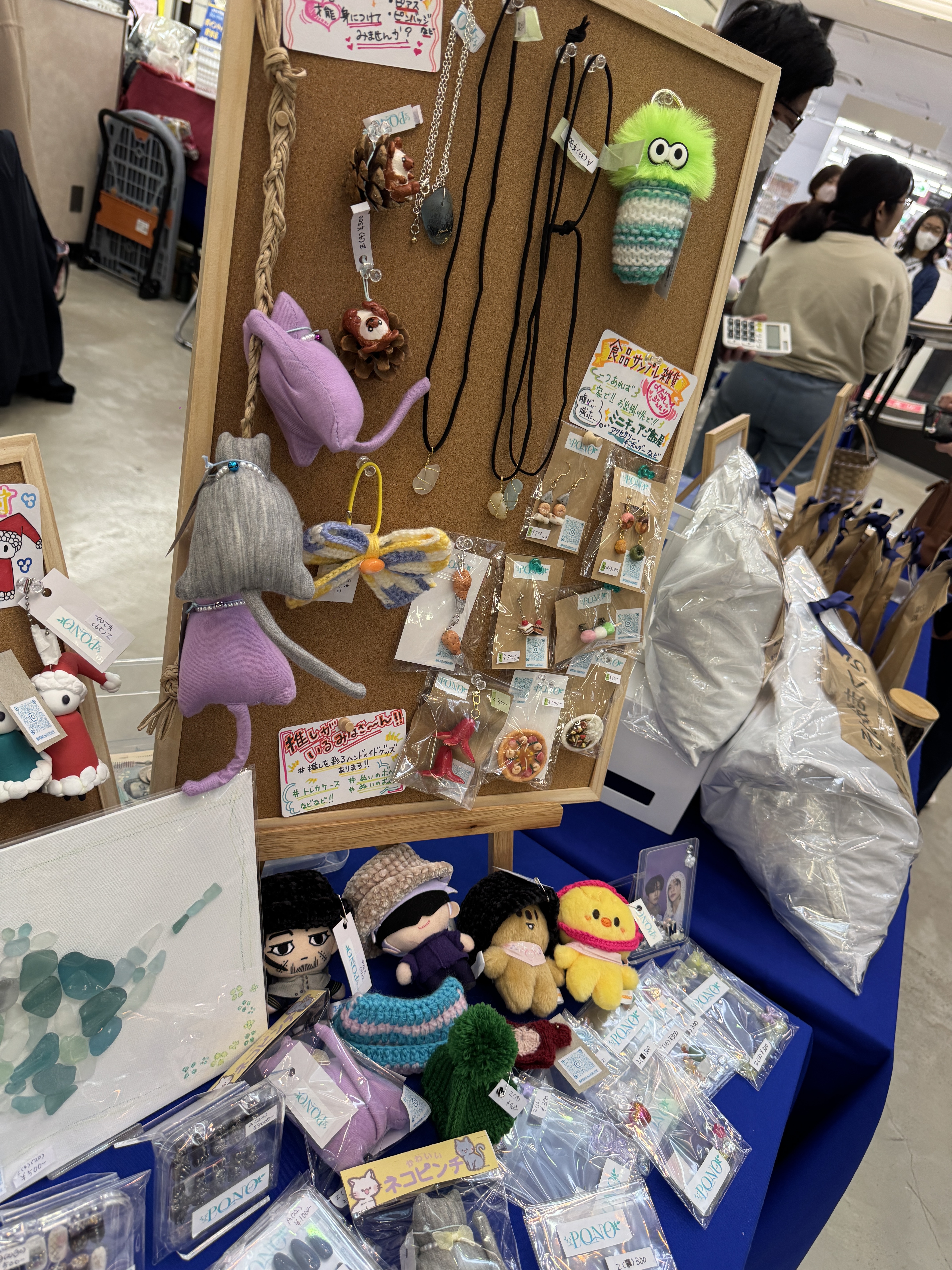 コルクボードに並ぶアクセサリーと手作り人形。PONOならではの手仕事が伝わる