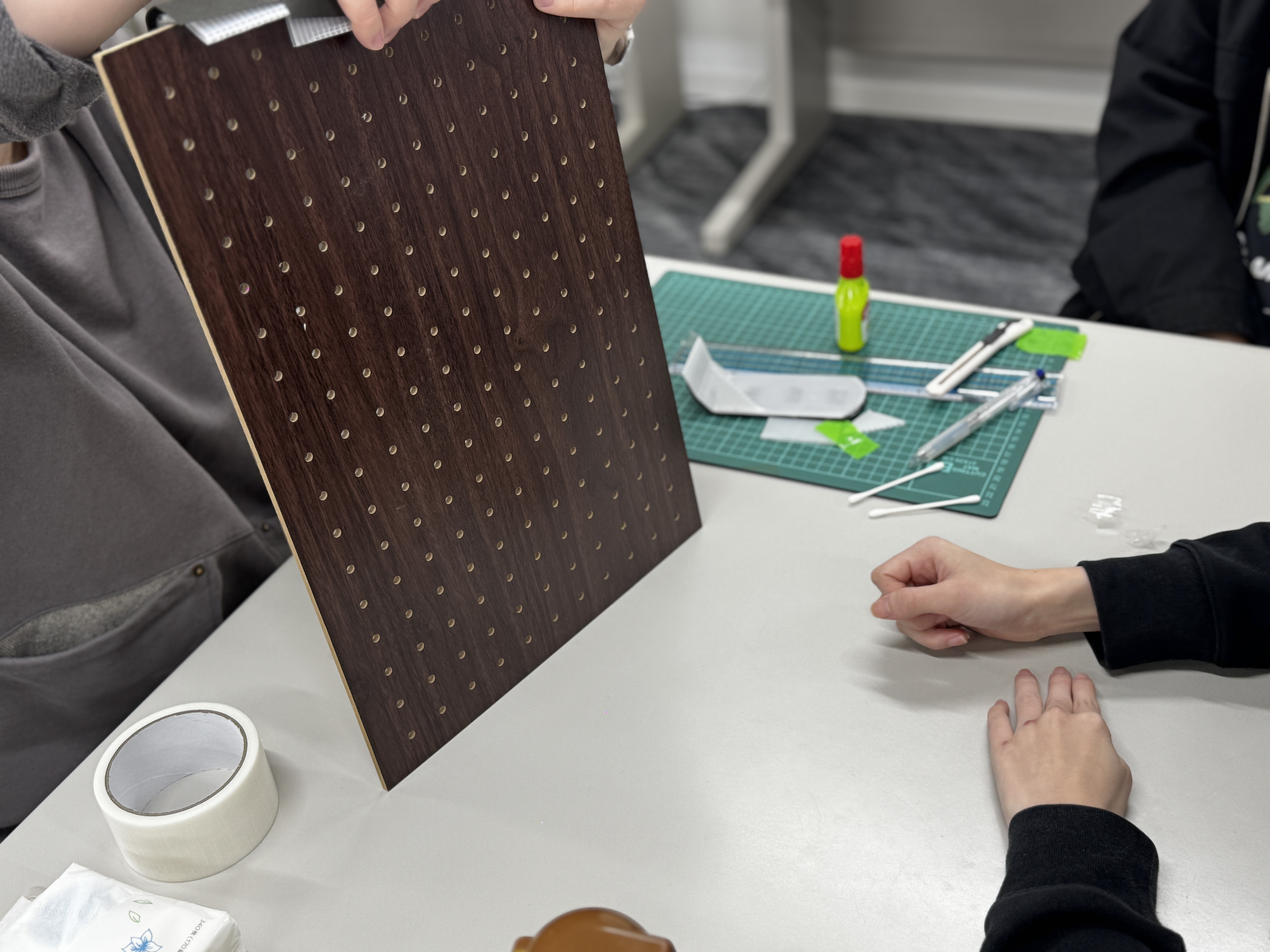 ダークウッド調のペグボードを手に取って確認している様子